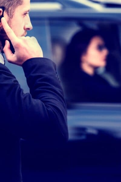 A close protection officer beside a vehicle